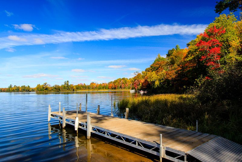 Pier and lake with blue sky and fall colors in Vilas County Wisconsin